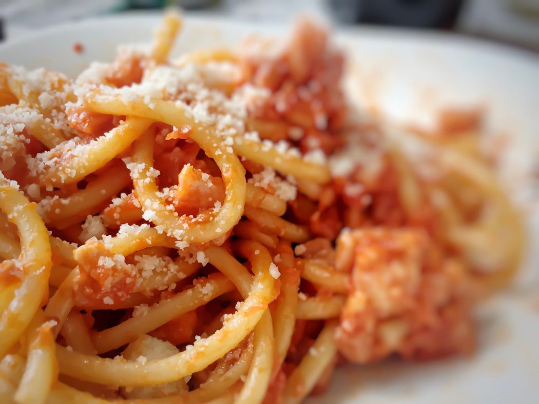 Homemade pasta bucatini amatriciana with tomato sauce and cured pork cheek and pecorino cheese